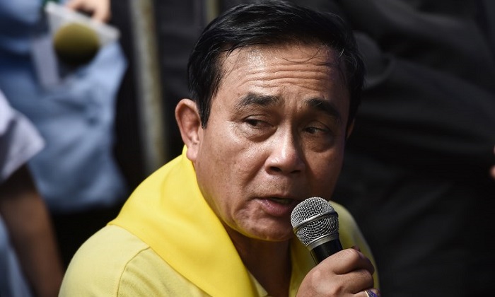 Thai Prime Minister Prayut Chan-O-Cha speaks to family members of missing children and their coach camping out at Khun Nam Nang Non Forest Park in Chiang Rai province on June 29, 2018 during rescue operation in Tham Luang cave. Divers resumed the search for 12 boys and their football coach who have been trapped in a cave in northern Thailand for six days after the underwater rescue was halted because of rising floods.  / AFP PHOTO / Lillian SUWANRUMPHA